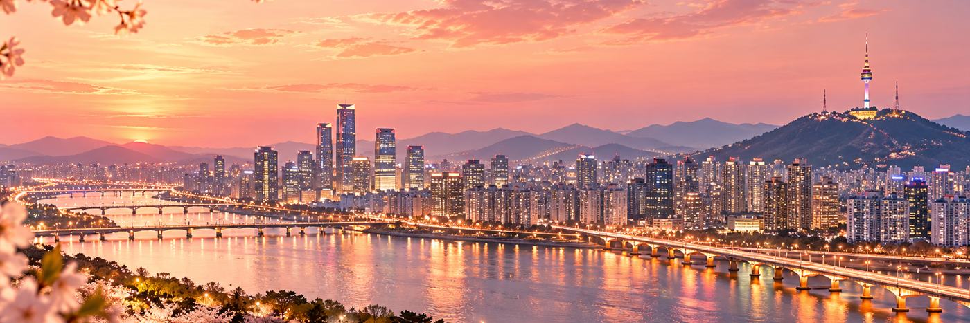 Seoul skyline and Han River at dusk with cherry blossoms